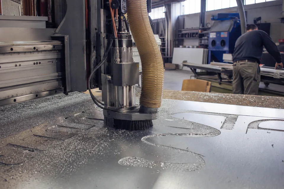 CNC router cutting aluminum letter faces in a sign shop