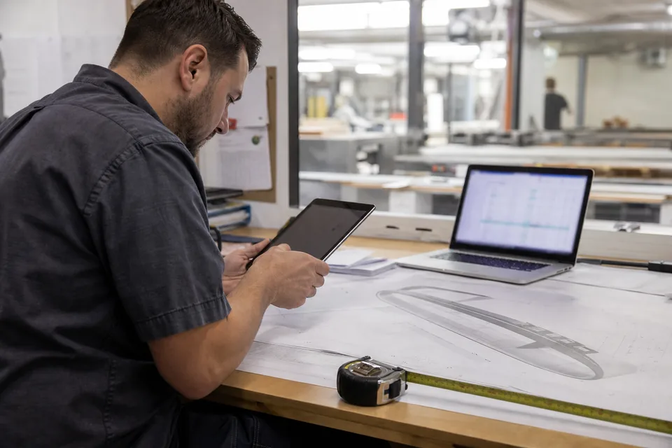 Sign shop estimator checking a channel letter estimate against shop drawings