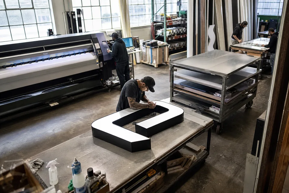Sign shop floor with a router, a printer and fabricators