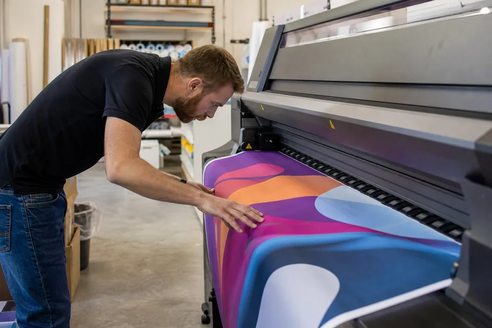 Wide format printer running an approved job in the sign shop print room